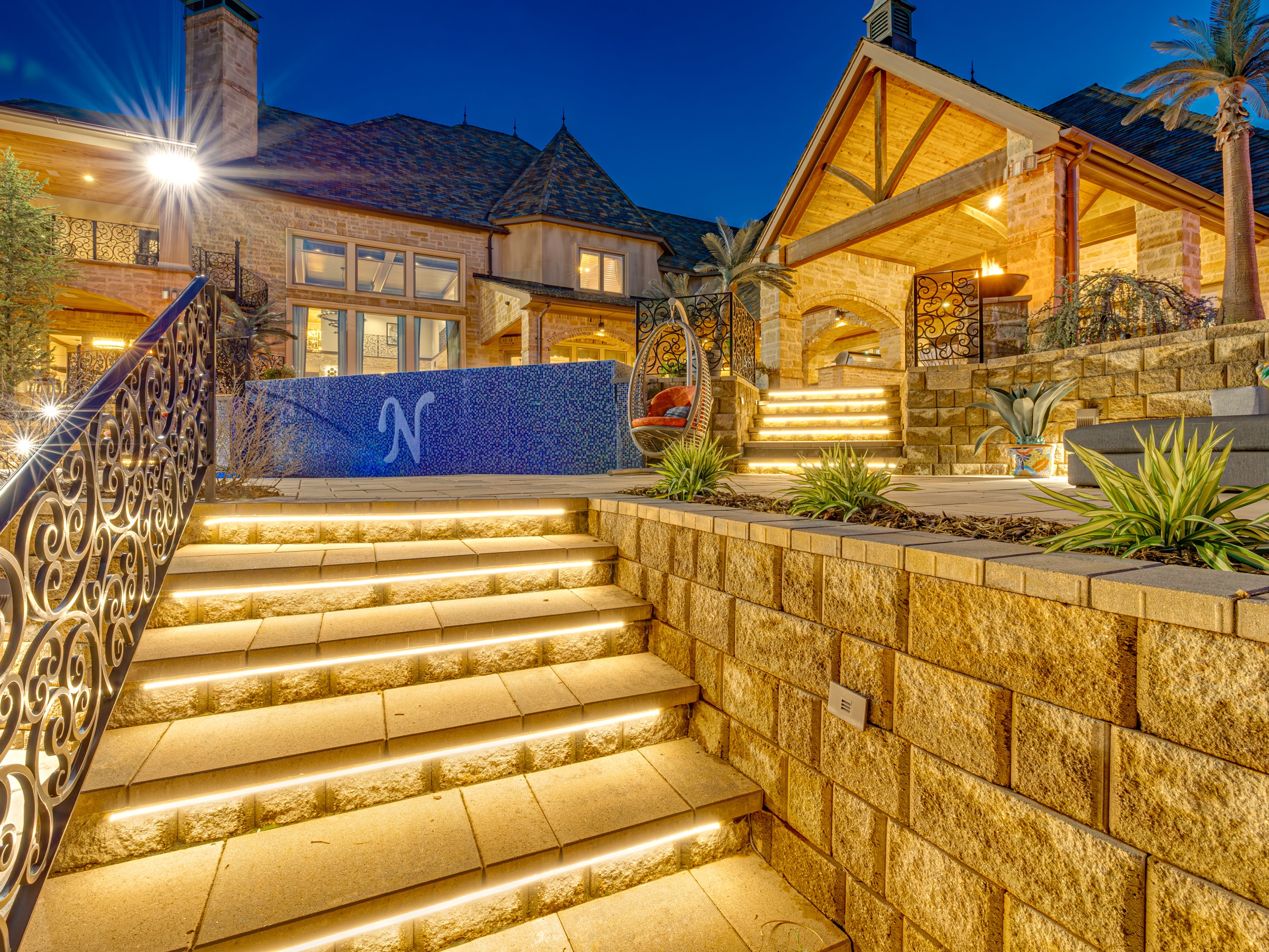 Illuminated estate steps and pool terrace at night